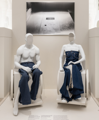 In the exhibition there is an image titled &lsquo;Street&rsquo; by Nolan Trowe on the wall. It is paired with a pair of Levi jeans made in partnership with the Disabled designer, Helen Cookman, and a denim jumpsuit by Lou Dehrot and Louise Linderoth. The jeans are presented on mannequins of Antwan Tolliver and Sonia Vera, both wheelchair users. Two mannequins in wheelchairs sit in front of a black and white photograph of the interior of an elevator. The mannequin on the left is wearing Levi denim jeans, and the mannequin on the right is wearing a denim jumpsuit.